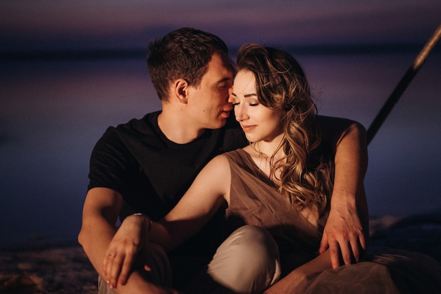 Young couple having a picnic on the beach of a pink lake