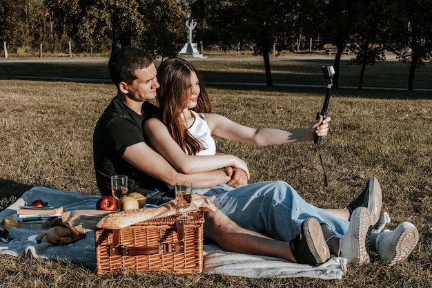 公園でピクニックを持っている若いカップル