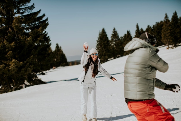 Young couple having snowball fight