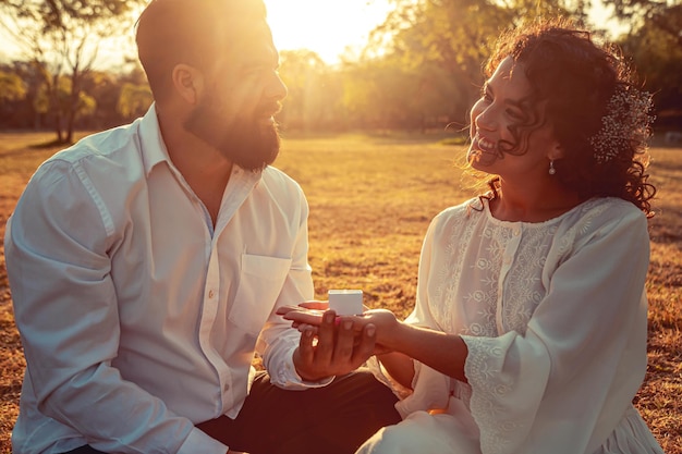 Young couple holding hands in a park at sunset