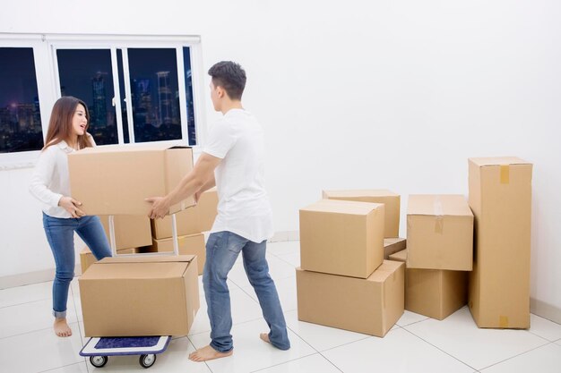 Young couple holds cardboard in the apartment