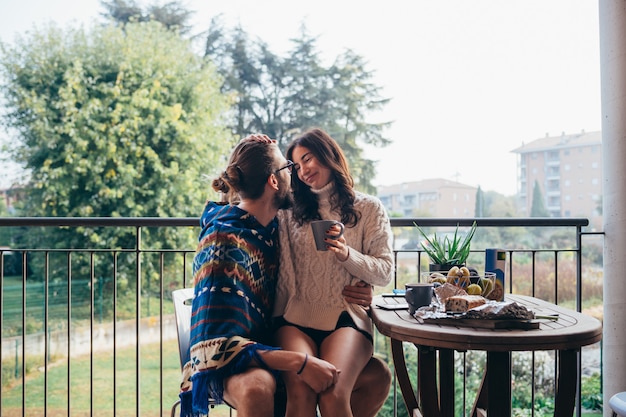 Young couple at home terrace having breakfast