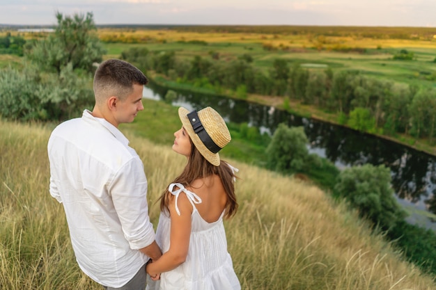 Young couple hugging in the field and looking at each other