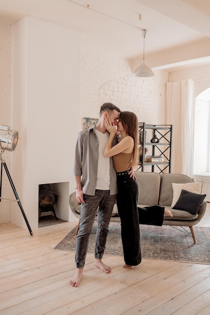 Young couple hugging and kissing at home in loft style interior Romantic couple of lovers