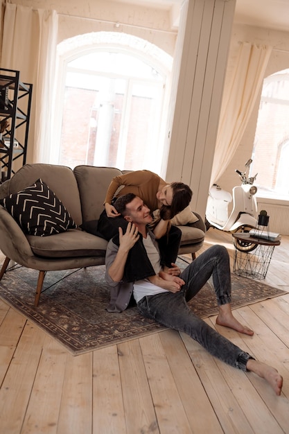 Photo young couple hugging and kissing at home in loft style interior romantic couple of lovers