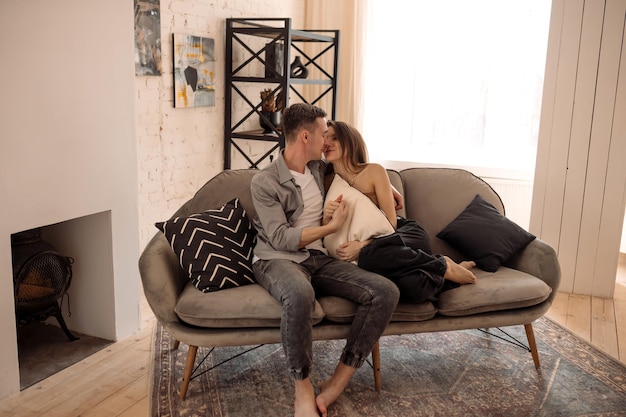 Young couple hugging and kissing at home in loft style interior Romantic couple of lovers