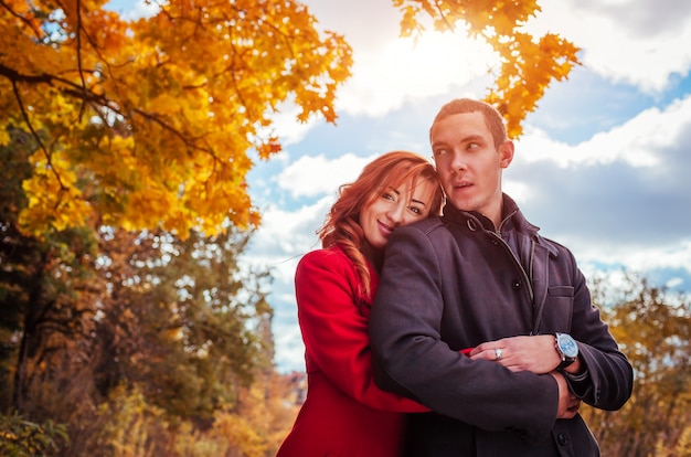 Young couple hugs in autumn forest. 