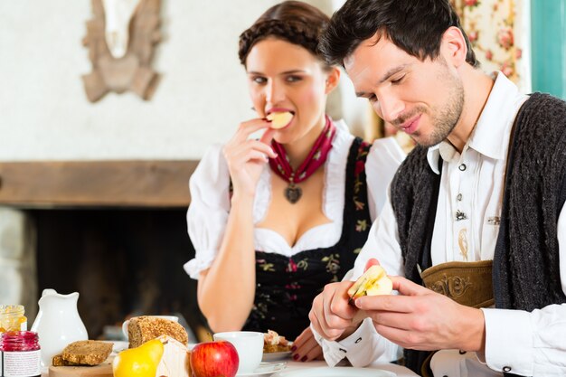 Young couple in a hunter's cabin eating