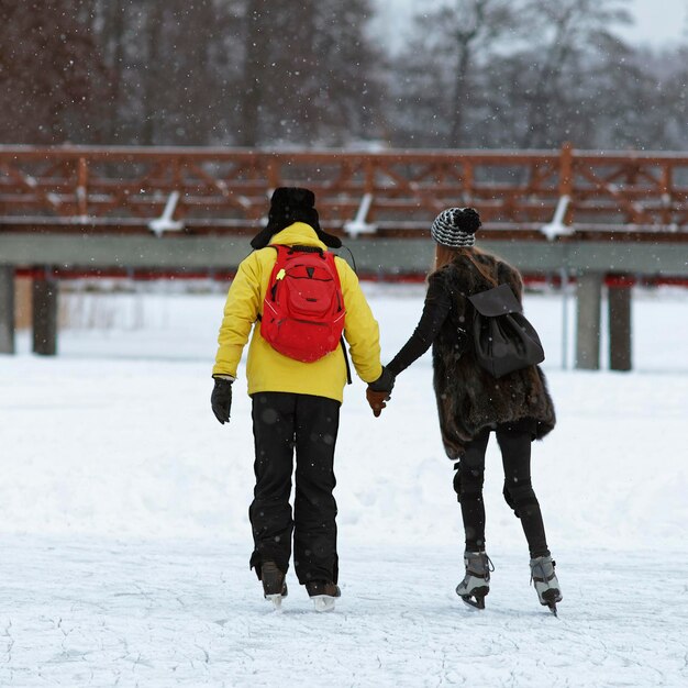 Young couple Ice skating on frozen lake of winter Trakai. Skating involves any activity which consists of traveling on ice using skates