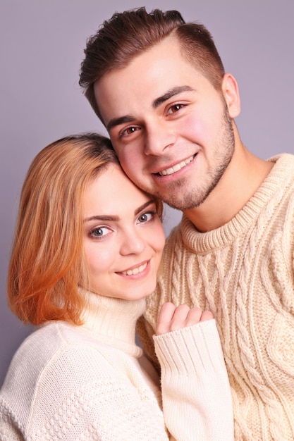 Фото Молодая влюбленная пара обнимается на сером фоне крупным планом