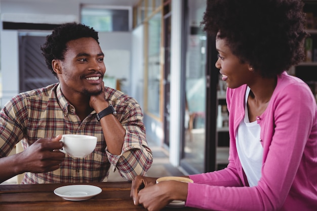 カフェテリアで互いに対話する若いカップル