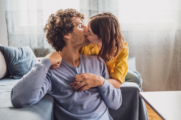 Young couple is embracing and kissing at their home