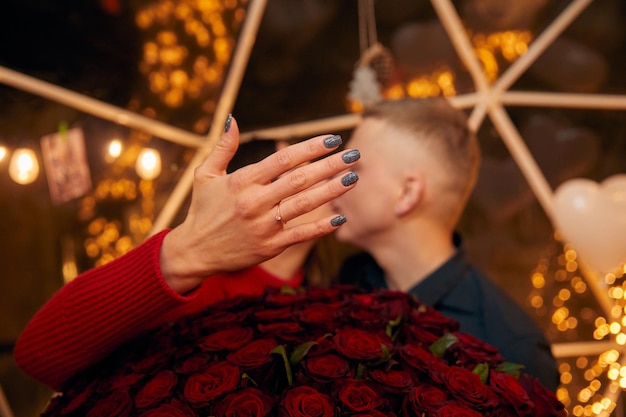 Young couple is getting engaged Romantic couples after proposal moment with bouquet of red roses