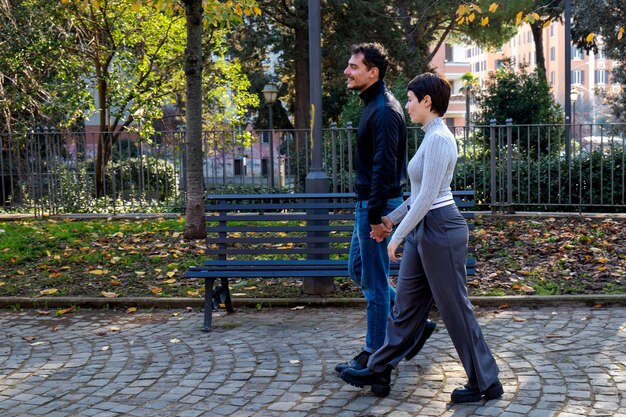 Foto la giovane coppia si tiene per mano la giovane coppia cammina in un parco di roma