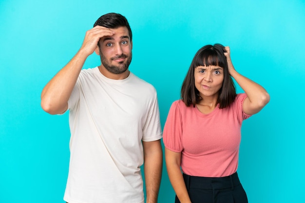 Foto giovane coppia isolata su sfondo blu con un'espressione di frustrazione e non comprensione