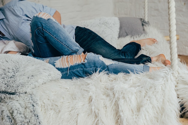 A young couple in jeans on a bed