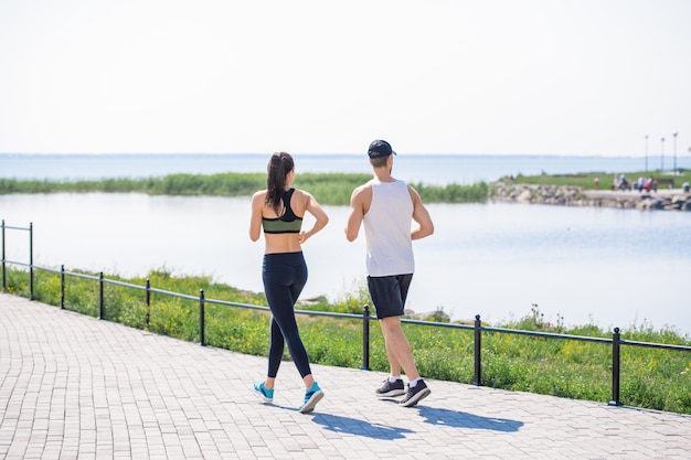 Young Couple Jogging by Lake