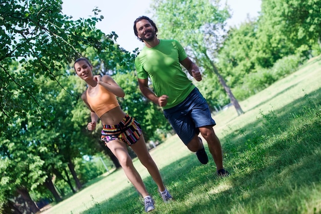 Young couple jogging at the green environment