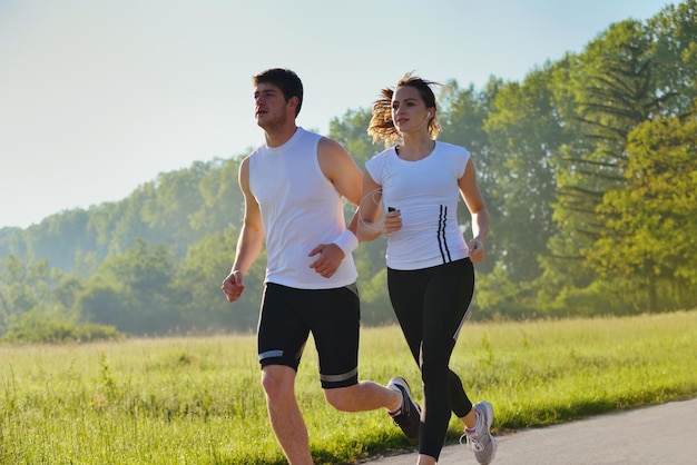 Young couple jogging in park at morning. Health and fitness concept