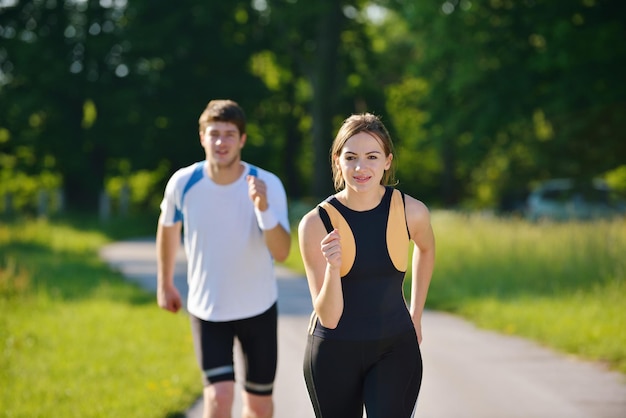 Young couple jogging in park at morning. Health and fitness concept