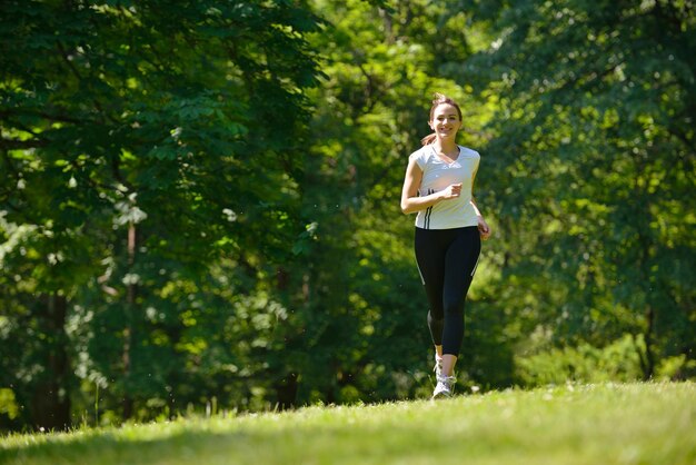 朝の公園でジョギングをしている若いカップル。健康と運動。