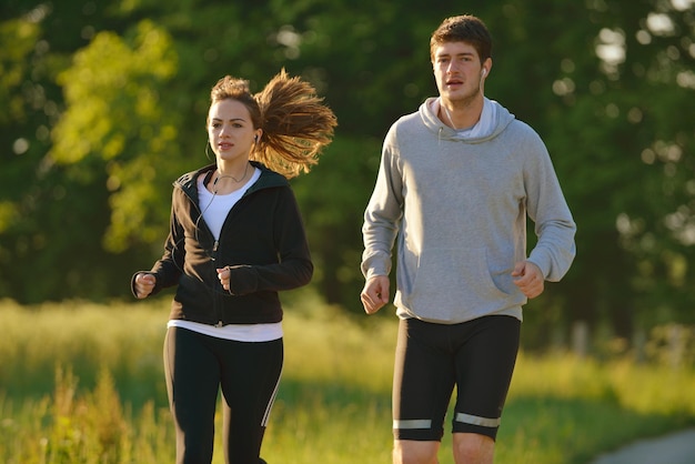 Foto giovani coppie che fanno jogging nel parco al mattino. salute e fitness.