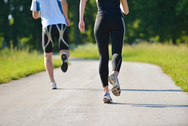 Young couple jogging in park at morning. Health and fitness.