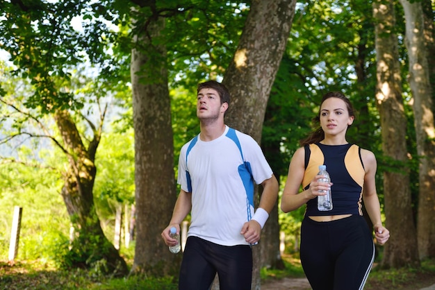 Young couple jogging in park at morning. Health and fitness.