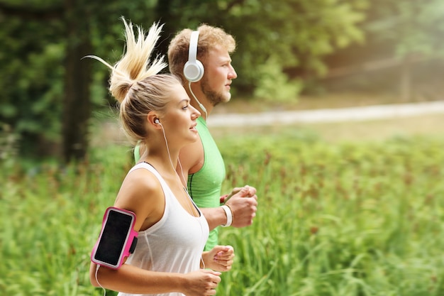 Photo young couple jogging in park in summer