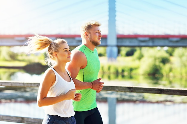 Young couple jogging in park in summer