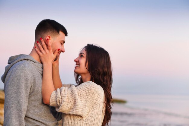 Young couple kissing against sky