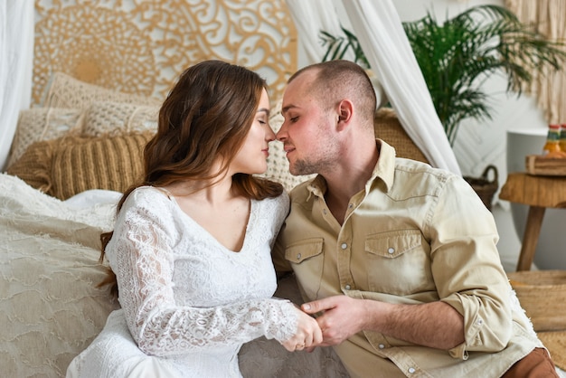 Young couple kissing by the bed.