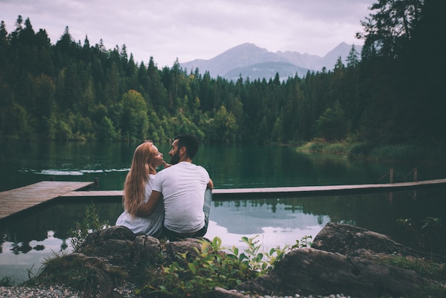 Young couple kissing in front beautiful lake landscape