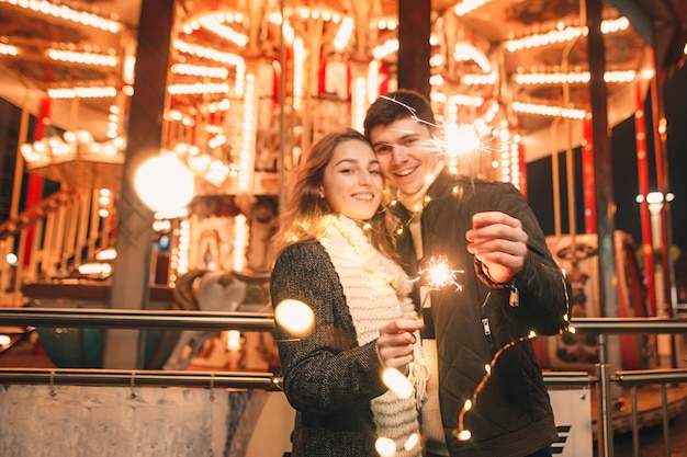 街のクリスマスの時期に夜の街で屋外でキスと抱擁の若いカップル