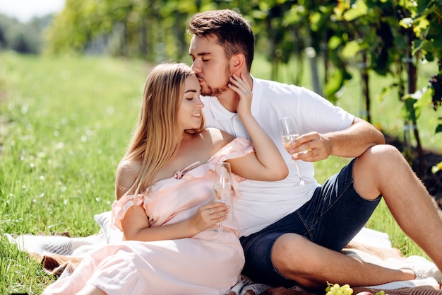 若いカップルがブドウ園でキスします。