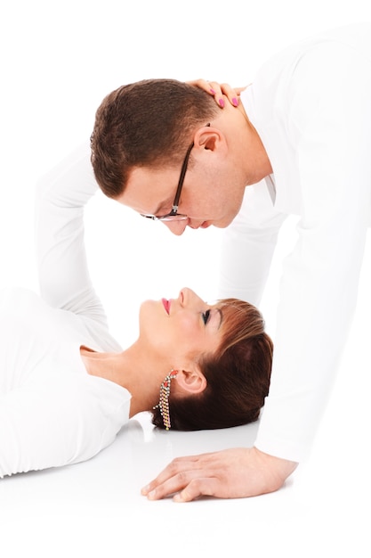 a young couple kissing over white background