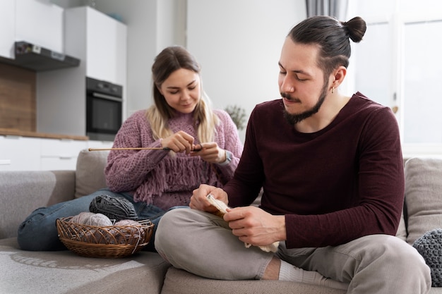 Young couple knitting together