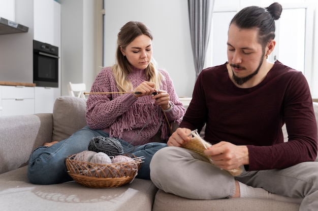 Young couple knitting together