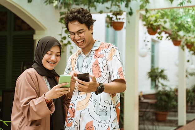 Young couple laughed while holding a cellphone