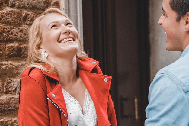 Photo young couple laughing against wall