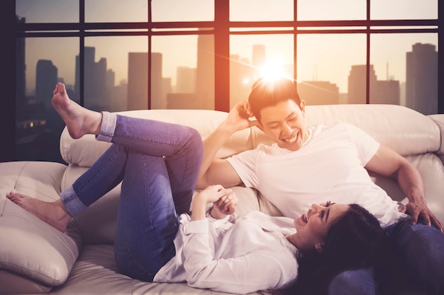 Young couple laughing and relaxing on couch