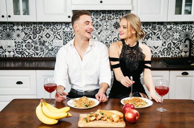 Young couple laughing while eating spagetti