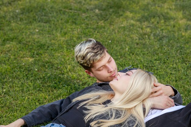 Young couple laying at the park on the grass