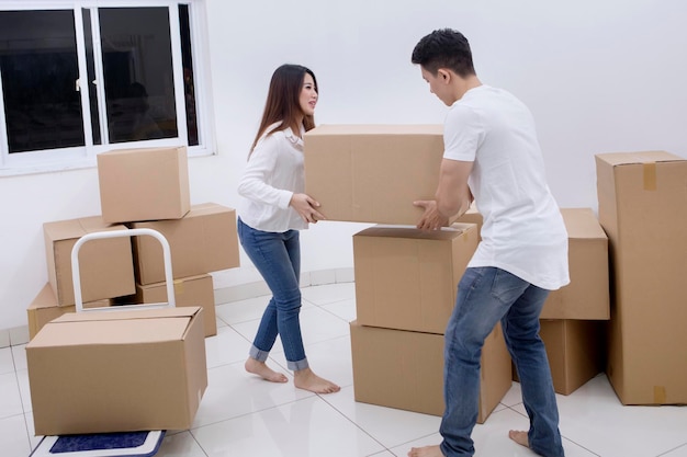 Young couple lifting cardboard together