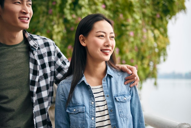 Photo young couple looking away while standing outdoors