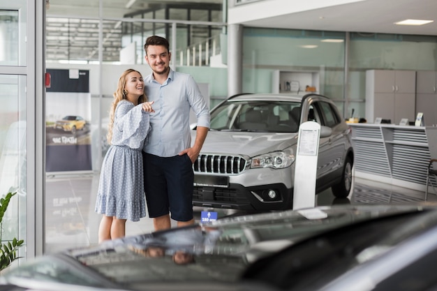 Giovani coppie che esaminano un'automobile