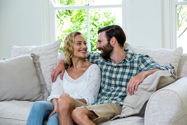 Young couple looking at each other on sofa