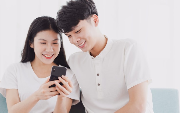 Young couple looking at the phone together with happy expression