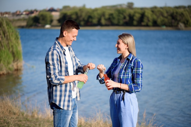 Giovani coppie nell'amore che gode del cocktail sulla spiaggia.