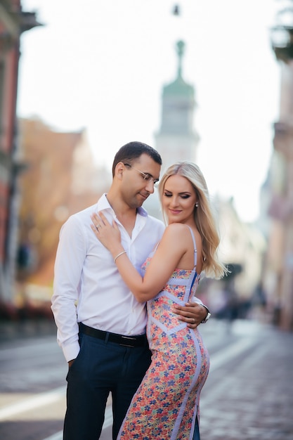 Young couple in love hug each other in city